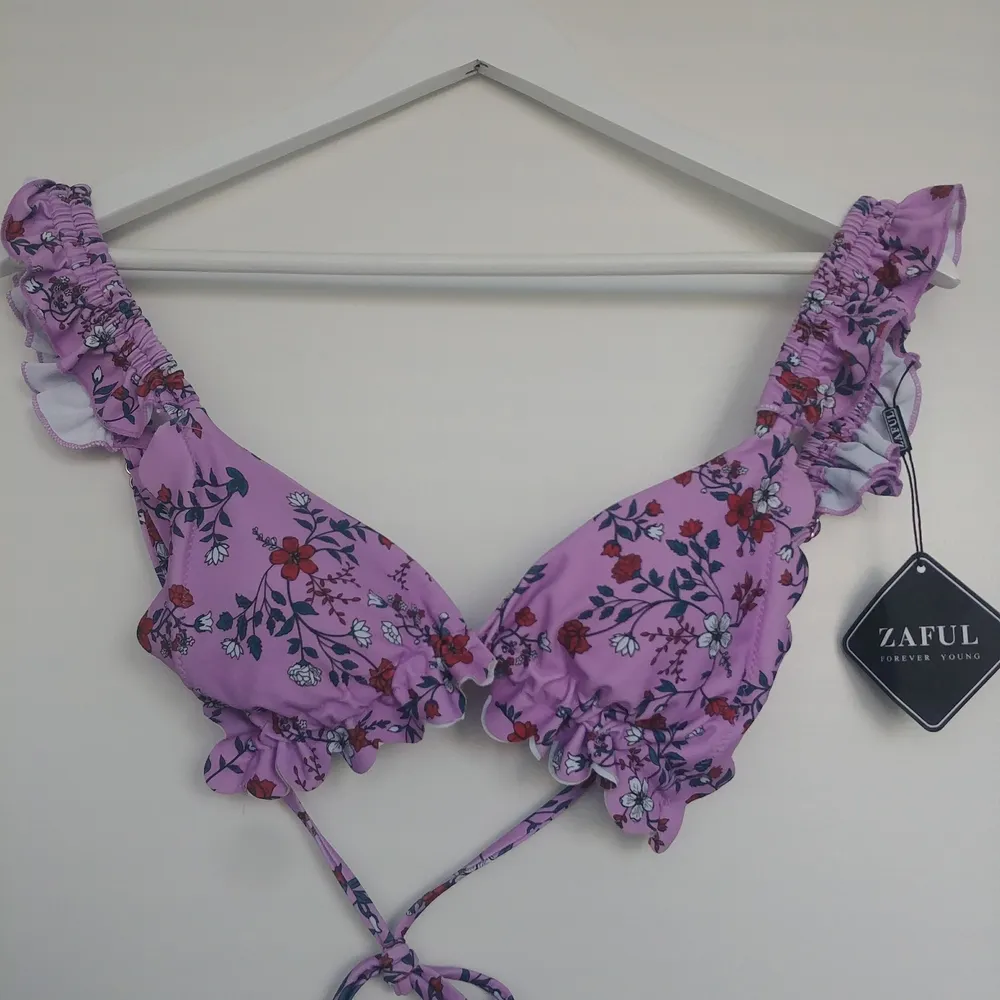 Så gullig bikiniöverdel från zaful i nyskick. Lila/rosa med blommor, knytning baktill och justerbara band. Stl 40 men mer som en 38. Skriv privat för fler bilder💕. Accessoarer.