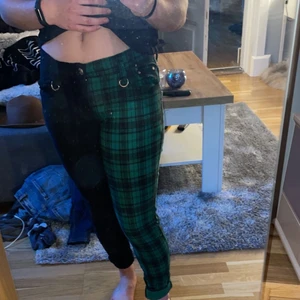 byxor - säljer mina jättecoola lågmidjade byxor med ena benet svart och andra svart/grön rutigt! säljer för att dom aldrig kommer till användning, sitter bra i benen men lite stor i midjan. köparen står för frakten<3