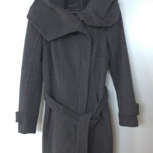 Nice and warm medium length (approx 90cm long) coat in gray color. The coat has a big and warm hood. The size is XS and the brand is Zara. Used, but in a good state.