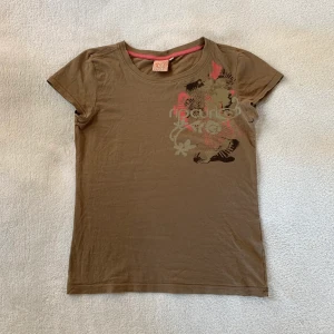 Brun t-shirt - Söt brun liten t-shirt med tryck från Ripcurl! Passar bra till lågmidjat 🤎