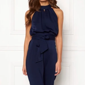 Mörkblå satin jumpsuit - Jättefin byxdress i mörkblått satin från Bubbleroom x Carolina Gynning. Inköpt för ca 700 och aldrig använd, saknar lapp dock. 