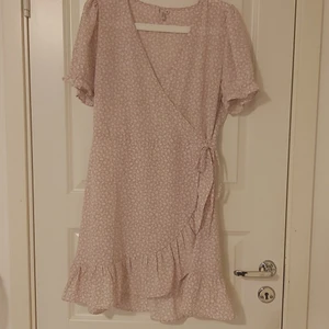 Ljusrosa klänning  - En ljusrosa klänning med vita blommor. Endast använd 1 gång. Klänningen är i st 38, den har en dragkedja i sidan och man kan knyta den. Den är väldigt lätt och passar varma sommardagar. Jag är 167 cm lång och den slutar en bit ovanför knäna på mig. Skriv ifall du har frågor!💗 Priset är exklusive frakt