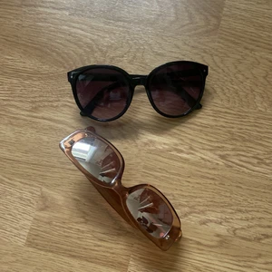 solglasögon  - Två stycken solglasögon. De svarta är i något sämre skick, rosa i gott skick. 