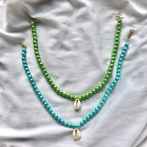 Pärlhalsband med snäcka  - Finns i blå och grön. Det finns endast ett grönt halsband. Justerbart med klolås och bindringar. Halsbanden ska vara nickelfria. Eftersom halsbanden är handgjorda så får du i͟n͟t͟e͟ e͟x͟a͟k͟t͟ s͟a͟m͟m͟a͟ h͟a͟l͟s͟b͟a͟n͟d͟.͟ Undvik kontakt med vatten och vätskor!! Ett halsband kostar 45kr +frakt eller båda för 83kr +frakt.   Kontakta vid intresse, frågor eller tydligare bilder! 💞