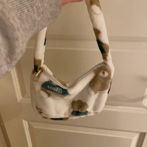 Axelväska - Axelväska i jättemysigt tyg med söta björnar på, passformen är bra och har aldrig använt den. Köpt för 120kr men säljer för 50kr då den är helt ny. Inga defekter och har en praktisk dragkedja så man ej tappar ut sina saker. Köparen står som vanligt för frakten💞