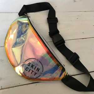 Magväska, hologram och knäppbälte - Cool lätt genomskinlig magväska i magiskt skimrande plast! Blandning av pärlemo och hologram. Kan justeras i bältet! Ny och oanvänd.  Kan mötas i Stockholm eller skicka mot fraktkostnad! ✨🌸✨