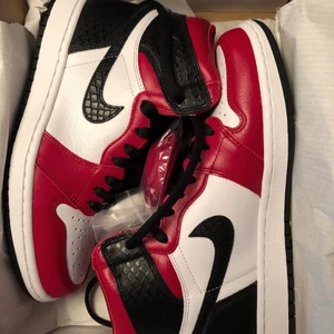 Jordan 1 Retro High Satin Snake Chicago storlek 39 - Säljer mina Jordan 1s som jag lyckades få tag på när dem släpptes i augusti. Endast använda ett fåtal gånger, knappt creasade. Finns dock två små märken på högerskon, syns knappt men värt att veta. Går säkert att fixa enkelt☺️ skickar med röda, svarta och vita snören. köpare står för frakt! 🖤