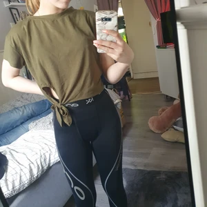 Grön t-shirt strl XS - Grön lite mer lössittande t-shirt med en knytning längst ner. Är i storlek XS men skulle även passa S, beroende på hur man vill att den sitter. Kan skicka den via post, eller mötas upp! (Köpare står för ev frakt)