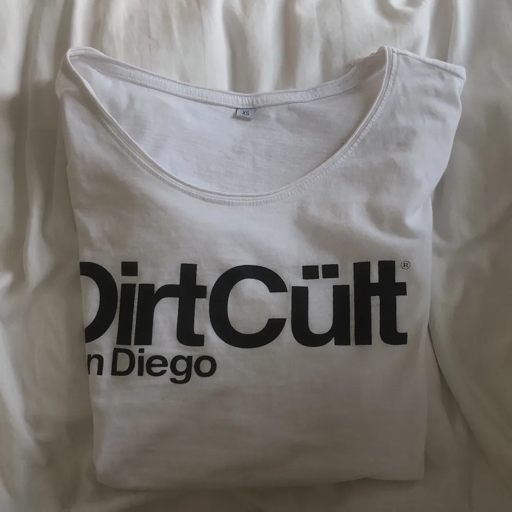 En vit t-shirt från märket dirt cult, aldrig använd.                    Lite längre där bak . T-shirts.