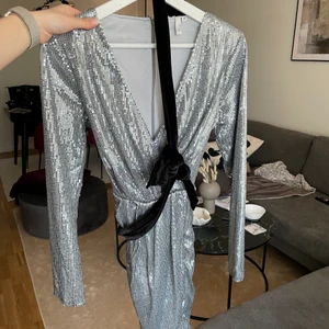 Paljettklänning  - Silvrig paljettklänning med svart sammetsband säljes efter bara 1 användning, perfekt nyårs/festklänning🤍 storlek 38 från nelly.com! 60kr+frakt