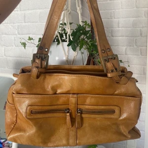 Brun väska - Snygg vintageväska i fejkskinn. Den är sliten i bandet längst upp, har även lite små revor på baksidan men inget stort, annars cool!