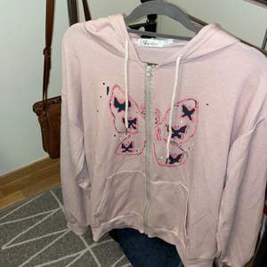 🌸Superfin ljusrosa zip-up hoodie med fjärilstryck på framsidan och även ett tryck på den vänstra ärmen (se bild 3). Denna hoodie är oanvänd och är därför precis som ny! Står att den är XL men den sitter som L. 50kr + frakt🌸