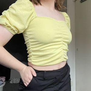 Croptop med puffärm strl S - Gul draperad croptop med puffärm från H&M i storlek S. Köpt för 150kr och är endast provad, så den har inga defekter eller slitage. Mjukt material på insidan. Säljer då den inte riktigt är min stil längre och tycker den är för liten. Passar XS-S. Kan samfrakta vid köp av flera plagg ☺️