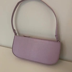 Lila väska - Ljuslila väska från NA-KD. Använd ca 5 gånger så nästan nyskick. Gör verkligen mycket till en outfit. Har två innefack. Säljer då jag inte använder den längre. Orginalpris 349kr. Pris 100kr. Köpare står för frakt (66kr).