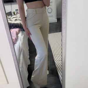 Kostymbyxor från Nelly.com - Beige kostymbyxor med skärp från Nelly.com. Riktigt snygga! Inte använda alls mycket