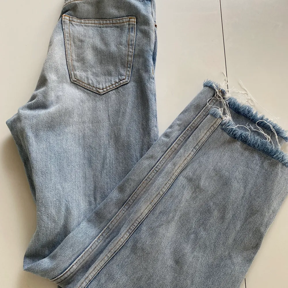 Ljusa MONKI jeans, hög midja, vida ben som är klippta/fransiga nedtill. 90-tals modell. Ganska små i storlek så passar 24-25. Snyggt slitna och sköna i tyget.. Jeans & Byxor.