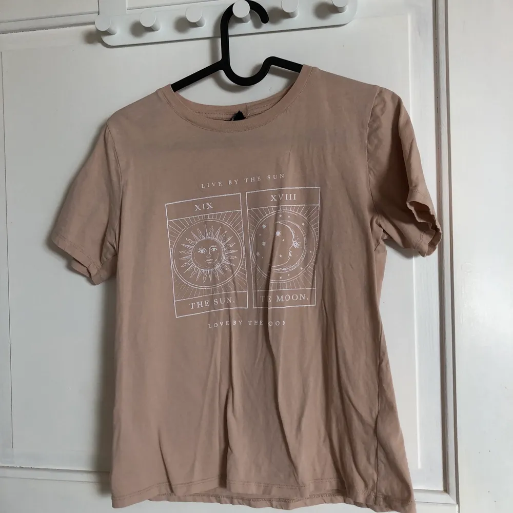 Beige T-shirt med tryck från ginatricot, säljs pågrund av att den blivit för liten. T-shirts.