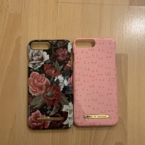 Ideal of Sweden skal 2 stycken iPhone 8+ - Två iPhone 8+ skal. Det mörka med blommor på har avskavd färg i hörnen, annars är det som nytt. Det rosa med bröst på (för att stött bröstcancerforskningen) har en spricka uppe vid kamerahålet och lite avskavd färg i något hörn. 
