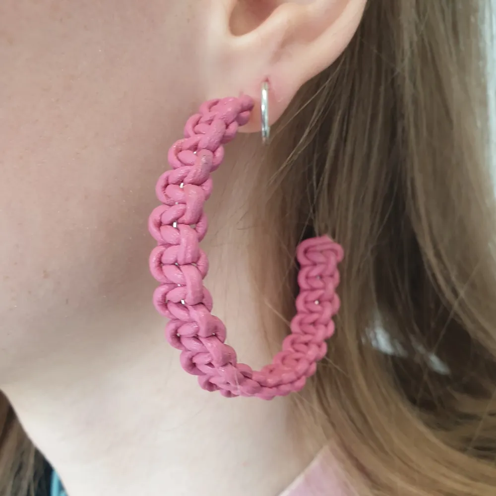 Örhänget är flätat i både rosa och blått läder. Accessoarer.