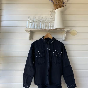 Zara, jeansjacka svart med nitar - Svart jeansjacka med nitat och stenar från Zara. Storlek XS. Men den är oversized så skulle säga att den passar en XS-M beroende på vilken passform man är ute efter. 
