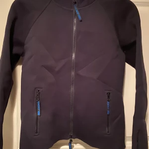 DKNY jacka - DKNY jacka i dykardräkts material. Svart med tryck på ryggen. Köpt i London, väldigt snygg och speciell. Åtsittande modell märkt XL men tycker den är mer som M. Jag på bilden har XS