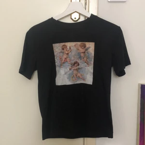 T-shirts med änglar  - En svart T-shirt med tryck med änglar på