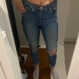 Jeans - Stretchiga jeans med hål i knäna och slitningar vid anklarn. Välidigr sköna då de är stretchiga. 