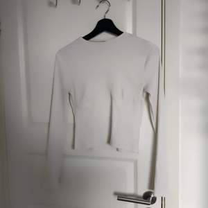 En vit långärmad tröja med boustier detaljer från H&M