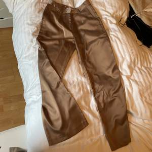 Skimrande bruna kostymbyxor i satin liknande material. Säljer pga för liten storlek. 