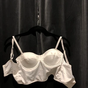 Vit bustier - Jättefin vit bustier i jättebra skick och väldigt skönt material. Den har väldigt fin färg och du kan spänna den tre gånger. Använd ca 2 gånger. Säljer pga att den inte riktigt passar mej och har inte den stilen tyvärr. 