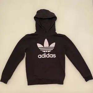 En svart Adidas originals hoodie i storlek 152. Hoodien har tyvärr ett igensytt hål på undersidan av den vänstra ärmen men är övrigt i gott skick. Hoodien funkar för både tjejer och killar. Den kan skickas eller mötas upp i linköping.