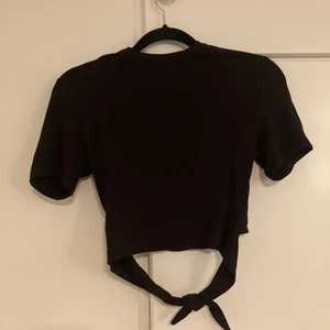 Crop top - Svart crop top, öppen rygg med rosett 
