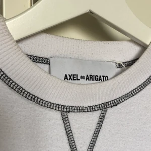 Axel Arigato tröja - Asball sweatshirt med ut&in effekt från märket Axel Arigato! Tyget vid trycket är alltså ”vanligt” medan resten är som det brukar vara inuti tröjor! Den har även en detalj med ”tvättlapp” på ryggen! Budgivning vid flera intresserade!
