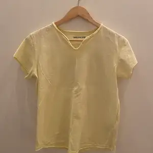 En Zadig Voltaire t-shirt i ljus gul. Cool detalj på ryggen. Sparsamt använd. Säljer pga för liten💛