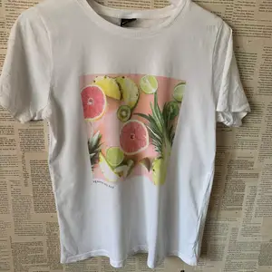 En t-shirt med frukt tryck samt en liten text under. Säljer pga inte använt och har redan för många t-shirts💜