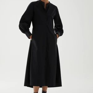 COS | Klänning  - Svart skjortklänning i bomull med markerad midja och ballongärmar. Enbart använd en gång, så som ny.  Pris: 250:- Storlek: 34