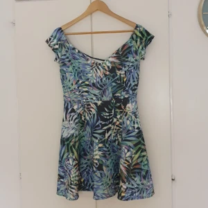 Klänning med fint mönster  - Färggrann klänning med möster av palmblad. 