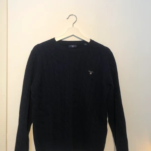 Stickad tröja från Gant  - Stickad tröja från Gant som är mörkblå i storlek 170 cm, 15 år.(S/M) Använd bara några få gånger. Frakt ingår ej. 