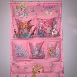 Rosa väggorganiserare - En rosa väggorganiserare med ett stort fack, tre små fack och två mellan stora fack. Ordinarie priset är runt 130kr. Mått: 36,5cm x 54cm. Fanns på kawaii.se förut men tror den har blivit borttagen. 