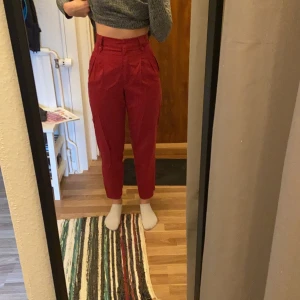 Röda/rosa superfina byxor - Säljer dessa röda/rosa byxor med hög midja. Lite noppiga och saknar en knapp (se sista bilden) men går lätt att sy dit. Slutar ovanför anklarna på mig (166). Köparen står för frakten. 