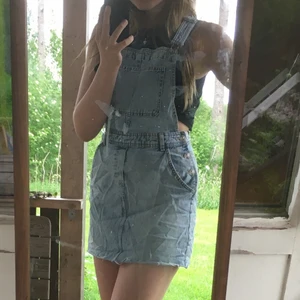 Hängselklänning i denim - Hängselklänning i denim, med fickor, i mycket fint skick, som använts ett fåtal gånger. Storlek 36. Jag bekostar frakten!