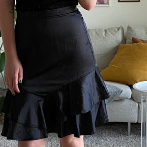 Midikjol - Oanvänd svart silkig kjol. Är 177cm och den går precis över knäna på mig. Passar 36/38. 