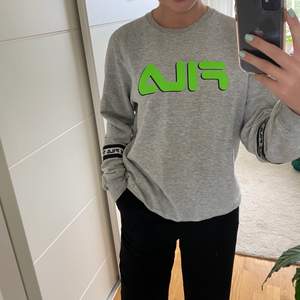 grå sweatshirt från Fila. märker är i neongrön färg. på armarna står det Fila i reflex. mycket skön💚