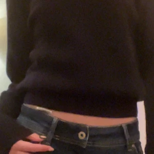 Svart stickad tröja  - Svart nästan mörkblå stickad tröja i strlk xs-s men skulle alternativ kunna passa medium. Lite lätt croppad och perfekt till lågmidjade jeans. Jag säljer för har ingen användning för den!