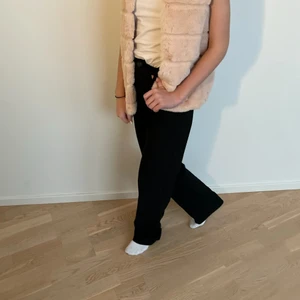 Rosa fluffig väst - Passformen är ganska lös och bra kroppsform med knappar hela vägen ner. Den är varm och storleken är 152 men är ganska stor. Modellen som bär västen har xs jag vanliga fall.