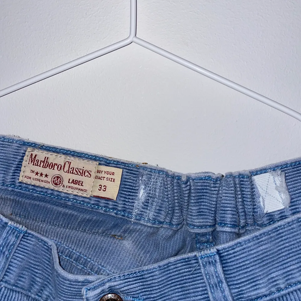 Babyblå Marlboro jeans i Manchester i storlek 33, insydda med ett resårband som enkelt kan tas bort. Skulle tippa på att de med resåren passar en medium.. Jeans & Byxor.