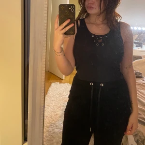 Svart linne med knytning - Säljer ett kort svart linne med knytning i mitten. Oklart vart det kommer från, storlek XS.