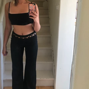 skitcoola byxor med cutouts framtill - svarta långa byxor , vintage, med häftig detalj där fram 😍😍 älskar dessa men kommer tyvärr inte till användning 😔 köpta second hand så storlek är diskuterbar, väldigt stretchiga så skulle passa en M men annars skulle jag säga storlek S! Jag har storlek S! EUPHORIA VIBES 💫⚡️⚡️⚡️⚡️🌚 kan bli budgivning 💕