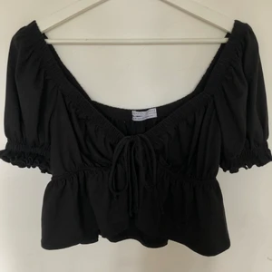 Svart topp från urban outfitters - Svart topp från Urban outfitters i XS. Knyts ”fast” i fram med hjälp av banden. Jättefin på men kommer inte till användning. Använd 1 gång och därav som ny. Högsta bud: 150kr
