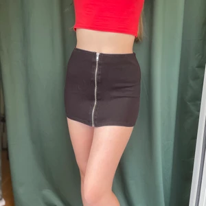 Minikjol H&M - Svart minikjol från H&M med funktionerande dragkedja. Strl 34.